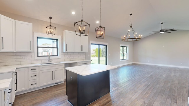 kitchen featuring white cabinets, ceiling fan, a kitchen island, and wood-type flooring