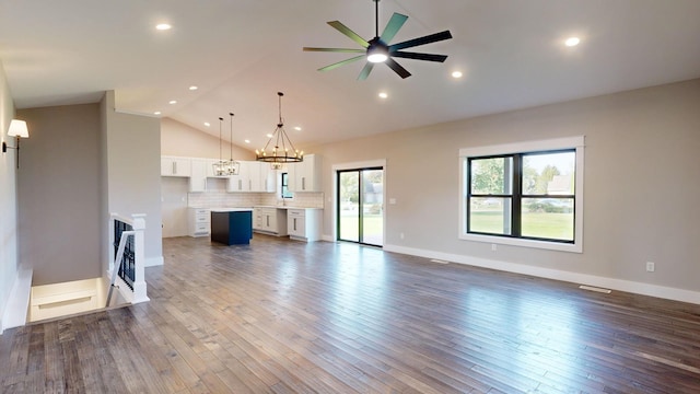 unfurnished living room featuring ceiling fan, high vaulted ceiling, and dark wood-type flooring