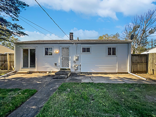 rear view of house with a lawn and a patio