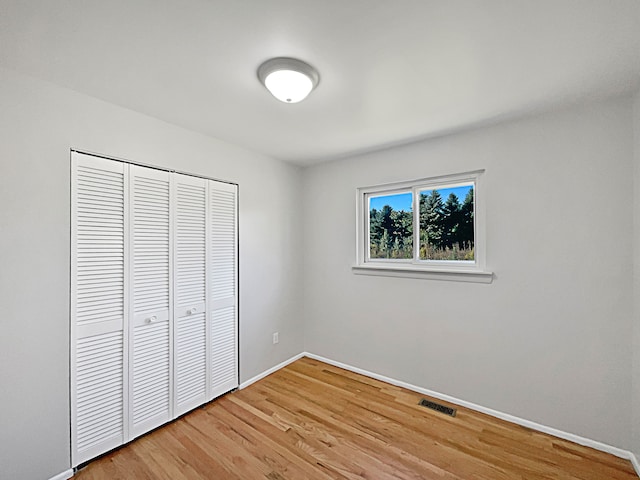 unfurnished bedroom featuring a closet and hardwood / wood-style flooring