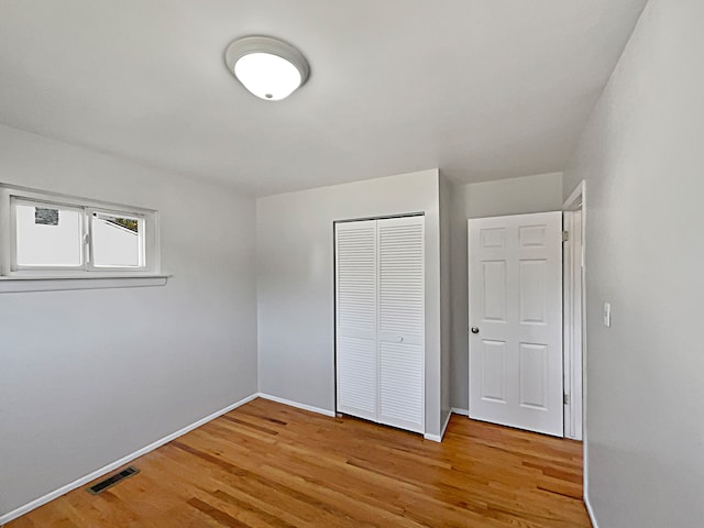 unfurnished bedroom with light wood-type flooring and a closet