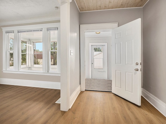 foyer with light wood-type flooring, plenty of natural light, and crown molding