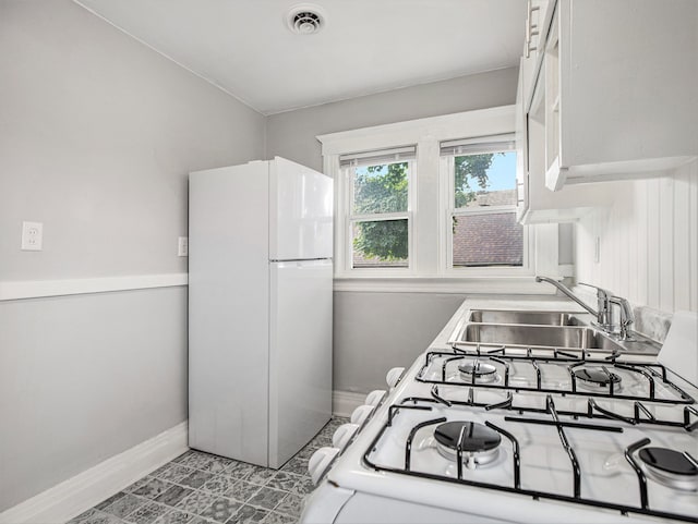 kitchen featuring white cabinetry, white appliances, and sink