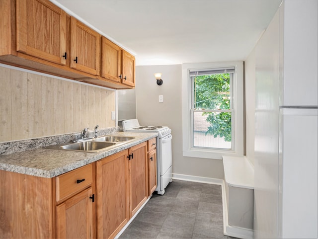 kitchen with dark tile patterned flooring, sink, and white stove