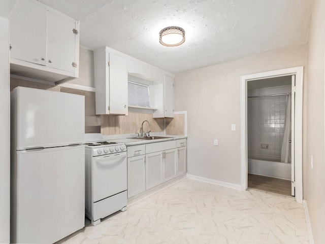 kitchen with a textured ceiling, white appliances, white cabinetry, and sink