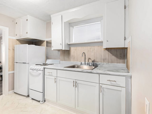 kitchen featuring white cabinets, white range oven, and sink