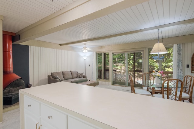 kitchen with ceiling fan, white cabinets, pendant lighting, and light colored carpet