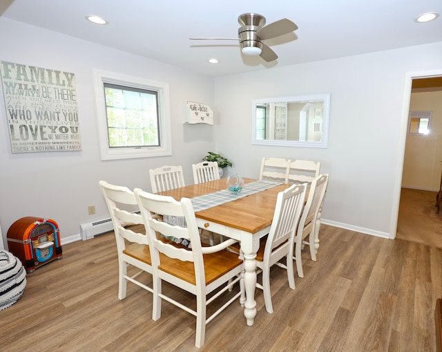 dining room with ceiling fan, a baseboard radiator, and light wood-type flooring