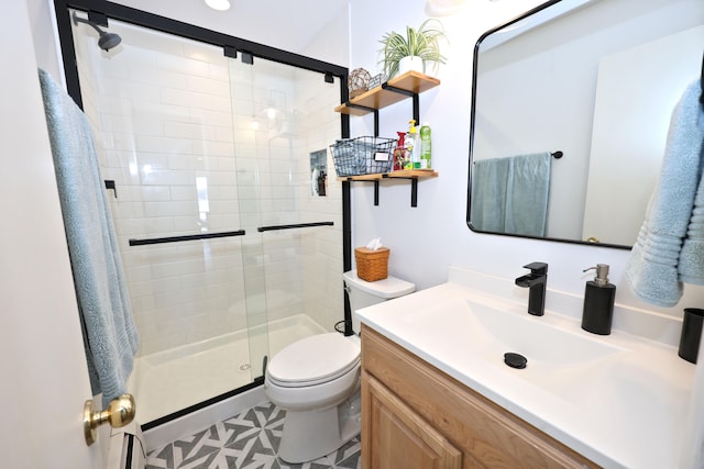 bathroom featuring tile patterned floors, vanity, toilet, and a shower with shower door