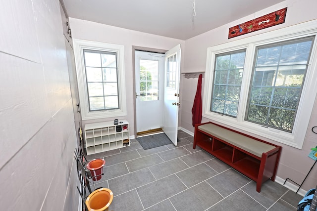 doorway to outside with dark tile patterned flooring