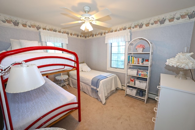 carpeted bedroom featuring ceiling fan and a baseboard heating unit