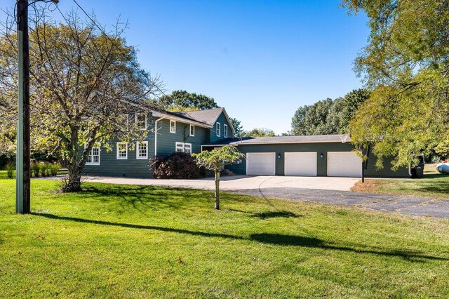 9695 Community Hall Rd, Union Pier, MI 49129 - view of front of house featuring an attached garage, asphalt driveway, and a front lawn