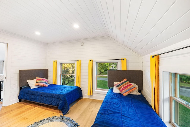 bedroom featuring wood walls, hardwood / wood-style floors, wooden ceiling, and vaulted ceiling