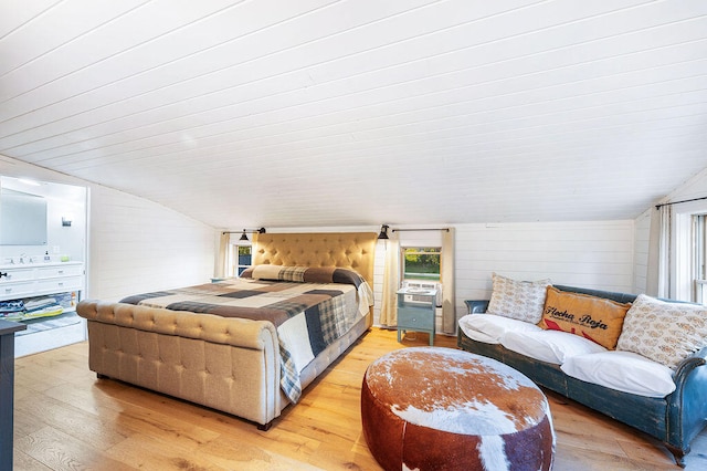 bedroom featuring hardwood / wood-style floors, wood walls, and vaulted ceiling