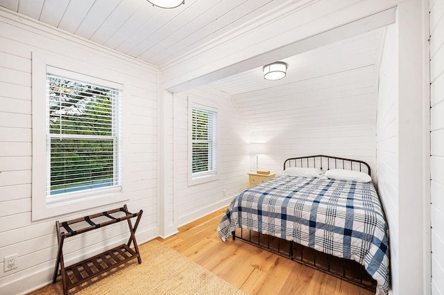 bedroom featuring lofted ceiling, wood-type flooring, wooden walls, and wooden ceiling