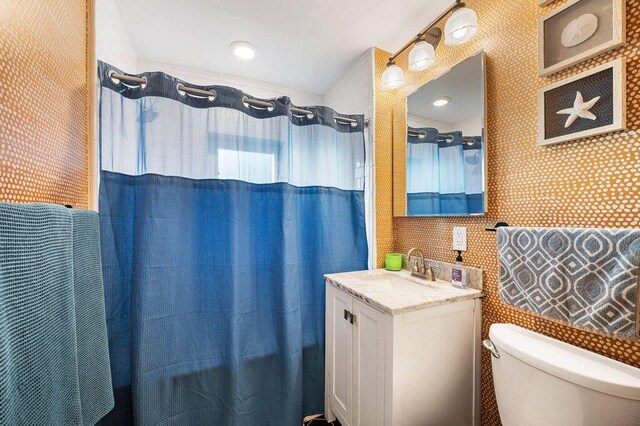 9695 Community Hall Rd, Union Pier, MI 49129 - full bathroom with toilet, vanity, and wallpapered walls