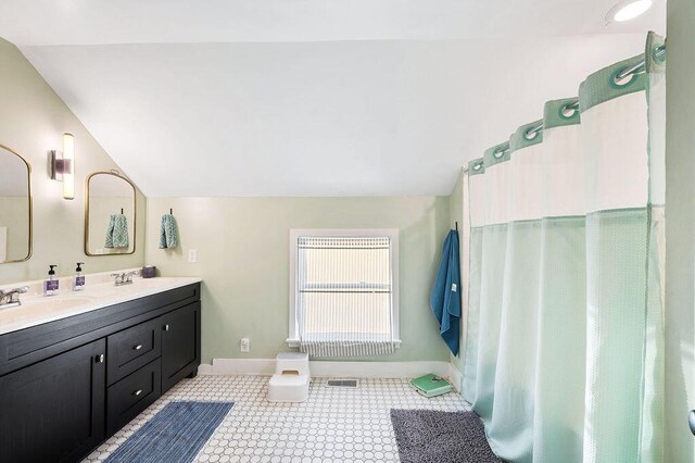 9695 Community Hall Rd, Union Pier, MI 49129 - bathroom featuring lofted ceiling, baseboards, and double vanity