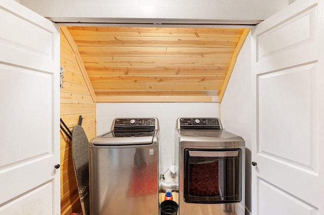 laundry area featuring washer and dryer, wood ceiling, and wood walls