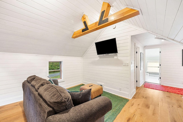 living room featuring wooden walls, hardwood / wood-style floors, wooden ceiling, and vaulted ceiling