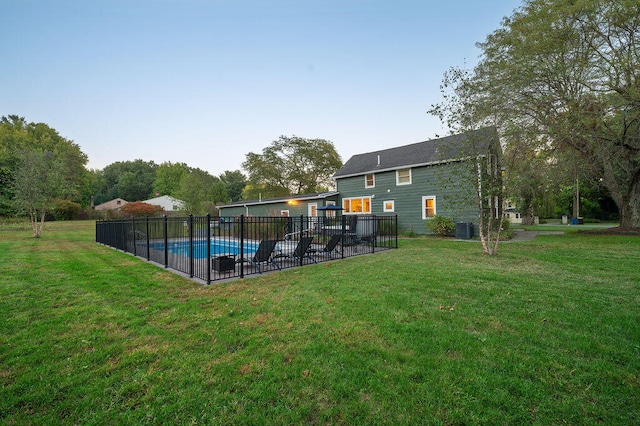 back of property featuring a yard, a fenced in pool, a patio area, and central air condition unit