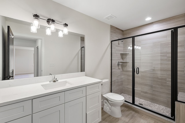 bathroom featuring hardwood / wood-style flooring, toilet, vanity, and walk in shower