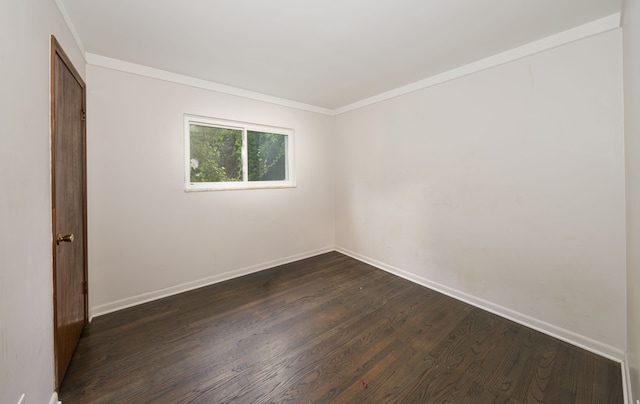 empty room featuring dark hardwood / wood-style floors and ornamental molding