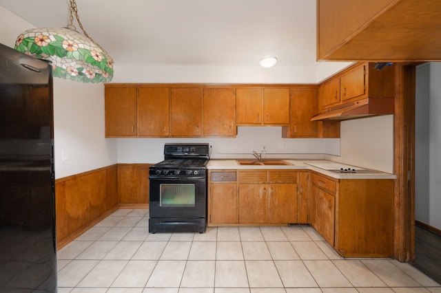 kitchen featuring sink, light tile patterned flooring, black appliances, and decorative light fixtures