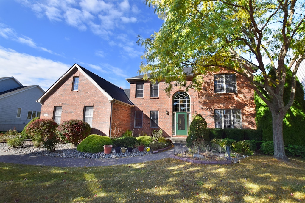 view of front of property with a front lawn and brick siding