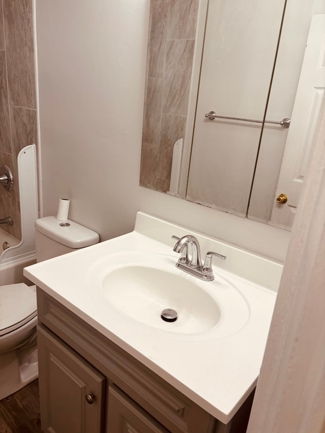 full bathroom featuring shower / tub combination, hardwood / wood-style floors, vanity, and toilet