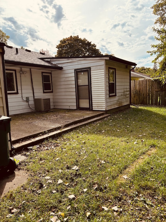 back of property with a lawn, cooling unit, and a patio