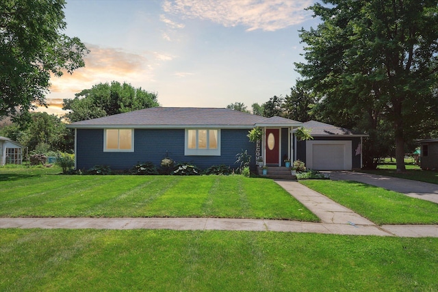 ranch-style home featuring a yard and a garage