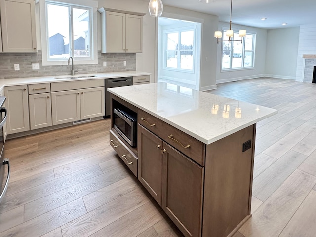 kitchen featuring sink, an inviting chandelier, light hardwood / wood-style flooring, pendant lighting, and stainless steel appliances