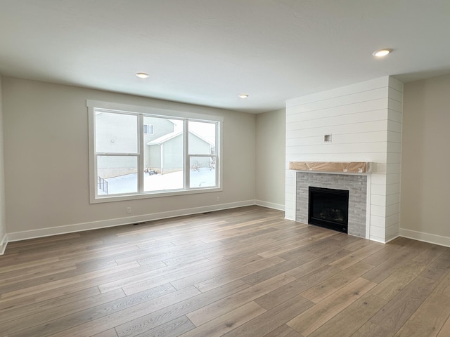 unfurnished living room featuring a fireplace and light hardwood / wood-style flooring