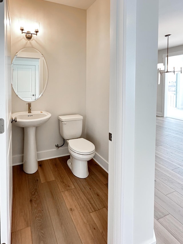 bathroom with sink, toilet, a chandelier, and hardwood / wood-style floors