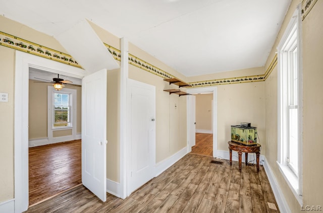 corridor with a barn door and wood-type flooring