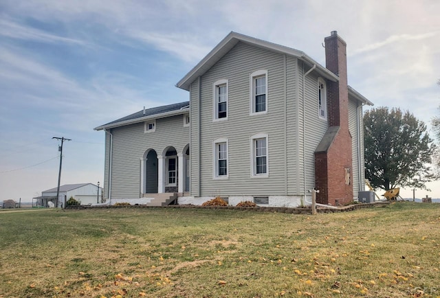 view of front of home featuring central AC and a front lawn