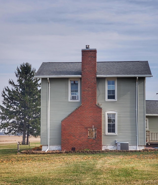 view of side of home featuring central air condition unit and a yard