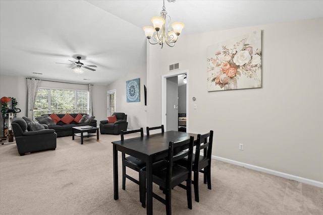 dining area with ceiling fan with notable chandelier and light colored carpet