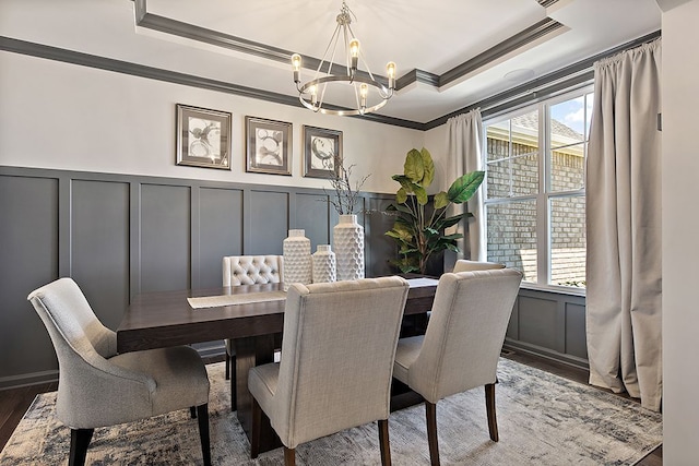 dining space featuring a raised ceiling, a wealth of natural light, dark hardwood / wood-style flooring, and ornamental molding