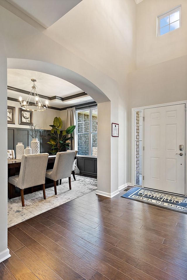 entryway featuring a tray ceiling, dark hardwood / wood-style floors, and a notable chandelier