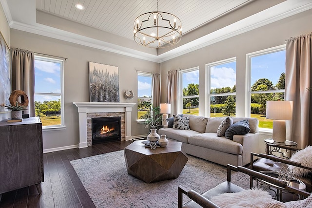 living room with a raised ceiling, plenty of natural light, dark hardwood / wood-style flooring, and a fireplace