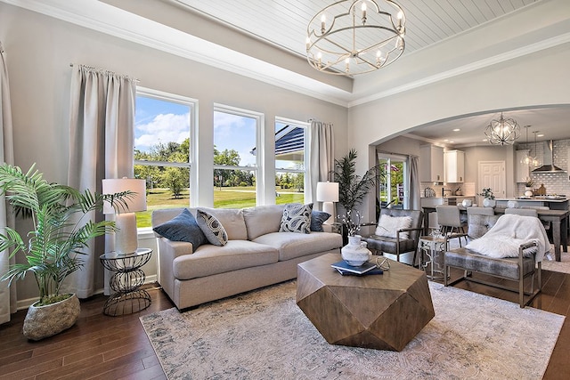 living room with hardwood / wood-style floors, ornamental molding, and a notable chandelier