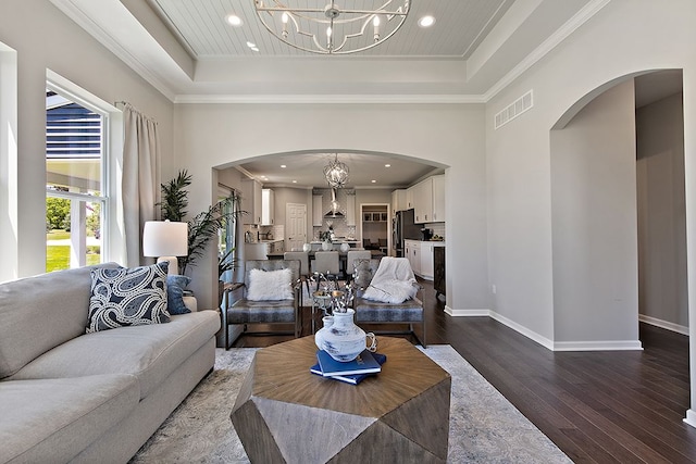 living room with hardwood / wood-style flooring, a raised ceiling, and ornamental molding