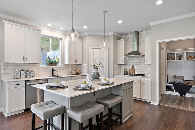 kitchen featuring stainless steel dishwasher, wall chimney exhaust hood, sink, dark hardwood / wood-style floors, and white cabinetry