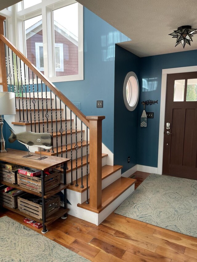 23739 Grandview Ct, Sturgis, MI 49091 - foyer featuring wood finished floors, stairway, baseboards, and a textured ceiling