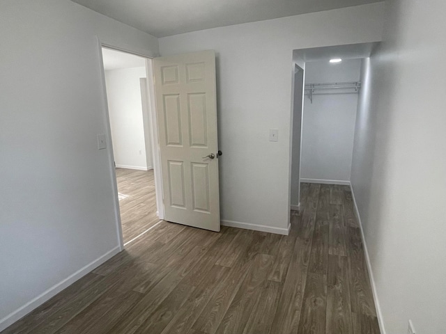 unfurnished bedroom with dark hardwood / wood-style flooring and a closet