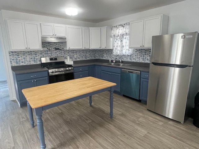 kitchen featuring stainless steel appliances, white cabinetry, hardwood / wood-style flooring, and sink