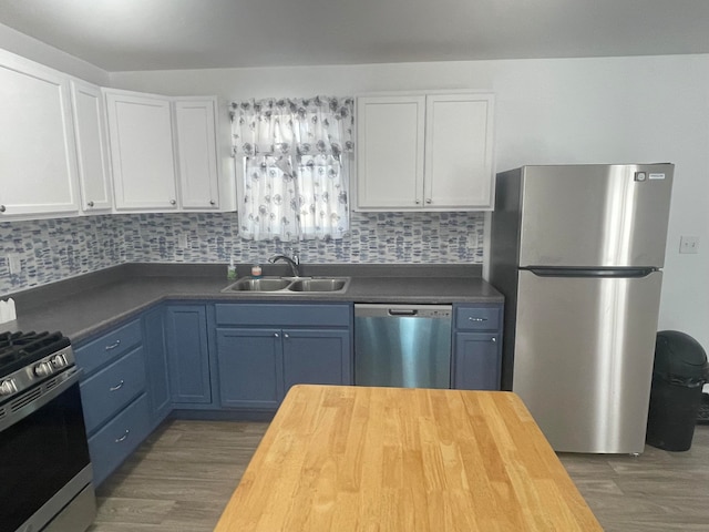 kitchen featuring sink, butcher block countertops, backsplash, white cabinets, and appliances with stainless steel finishes