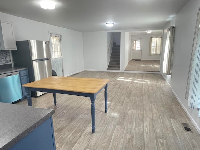 interior space with blue cabinetry, appliances with stainless steel finishes, and light hardwood / wood-style flooring