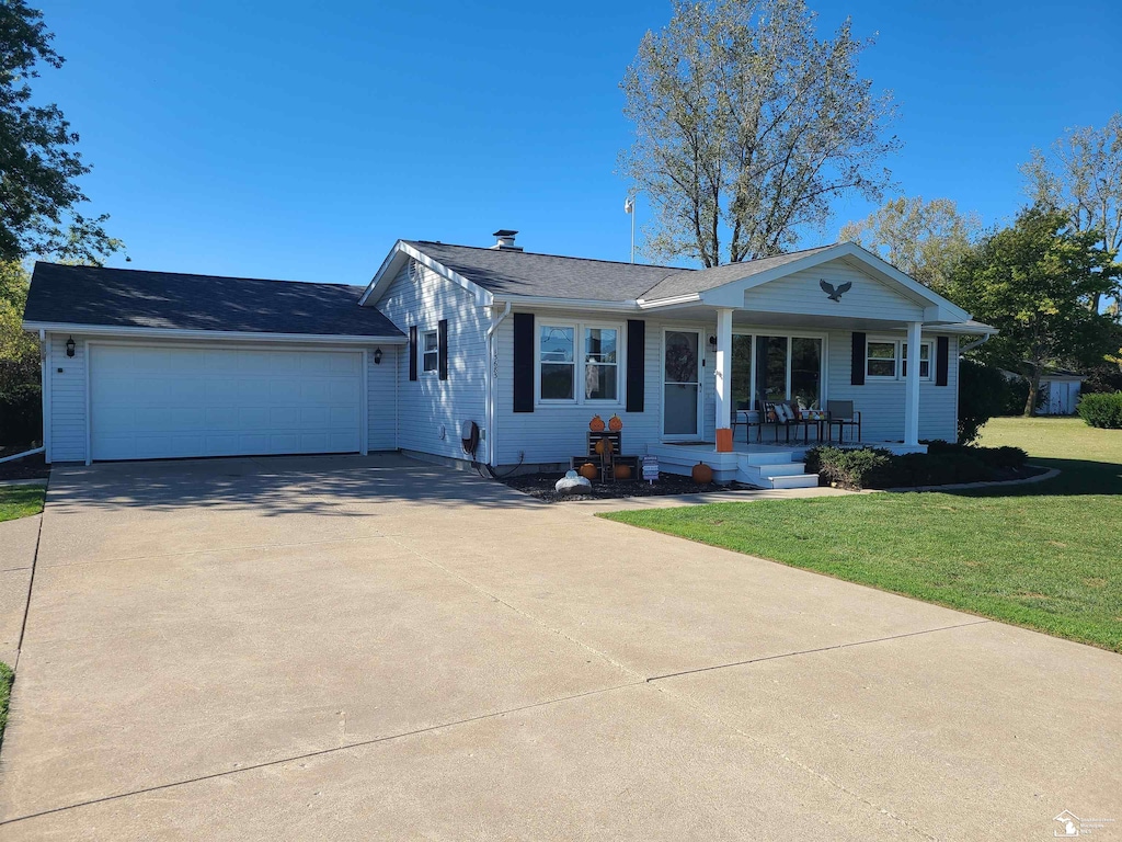 ranch-style house featuring a front lawn, covered porch, and a garage